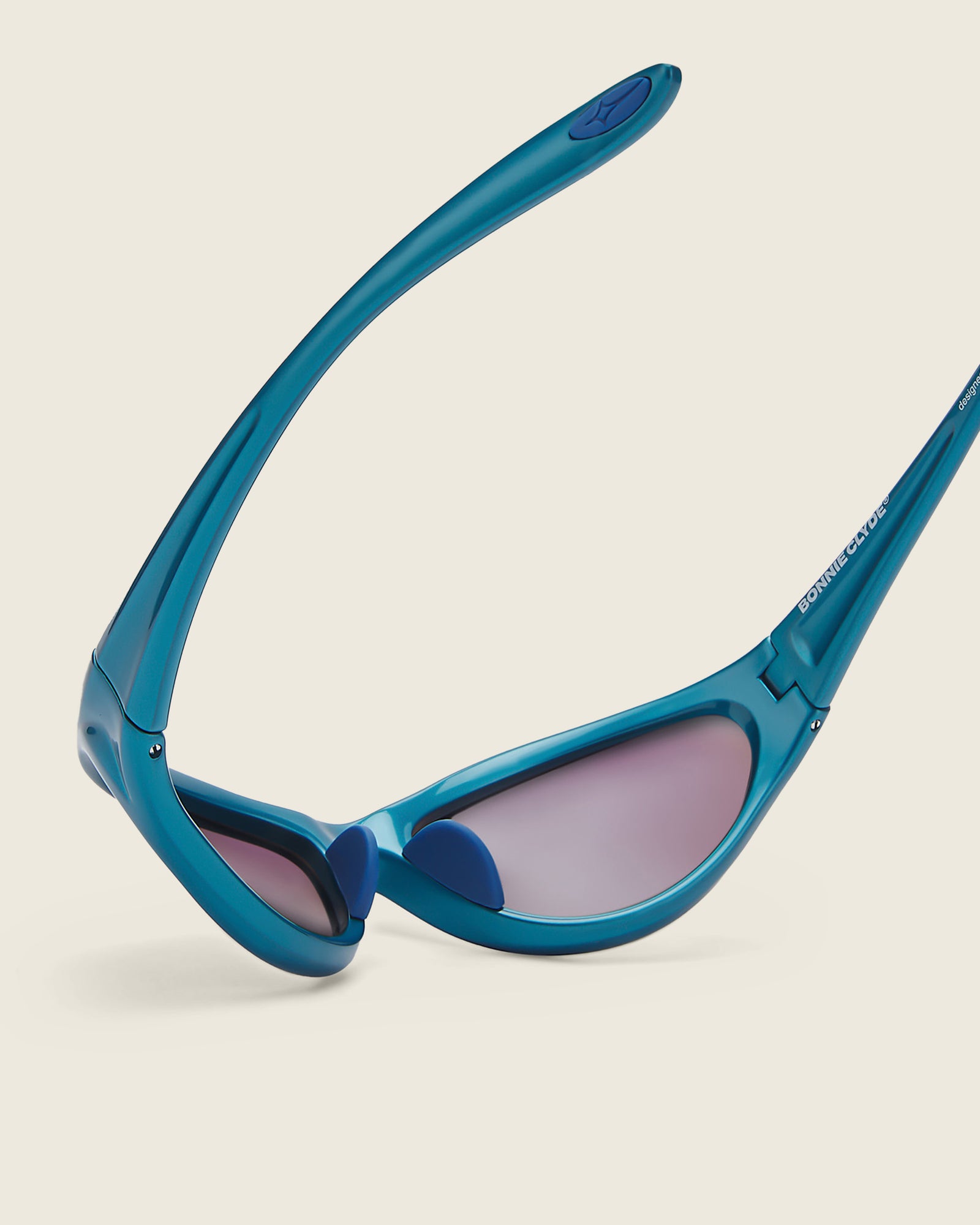 Bonnie Clyde Angel metallic blue curved TR90 sunglasses with blue lenses, detail view.