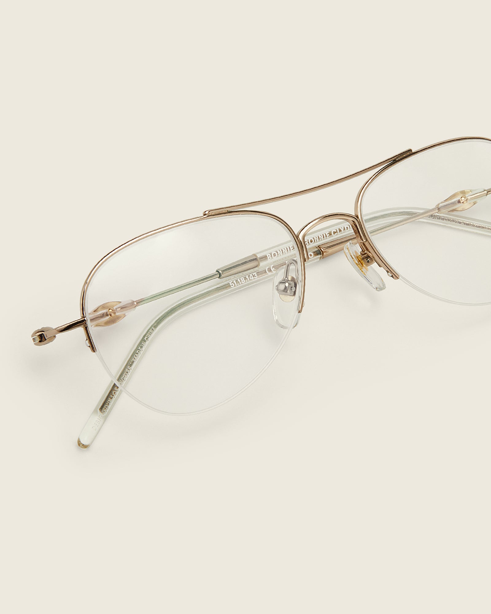 Bonnie Clyde Autobio aviator opticals in gold titanium with clear lenses and exploding heart acetate bead detailing on the arms, detail view.