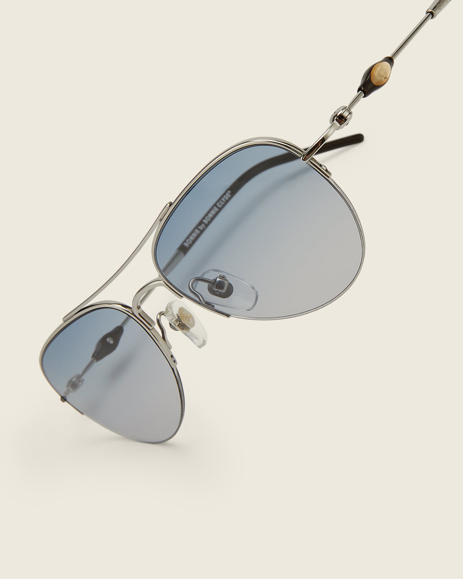 Bonnie Clyde Autobio aviator opticals in silver titanium with blue lenses and exploding heart acetate bead detailing on the arms, detail view.