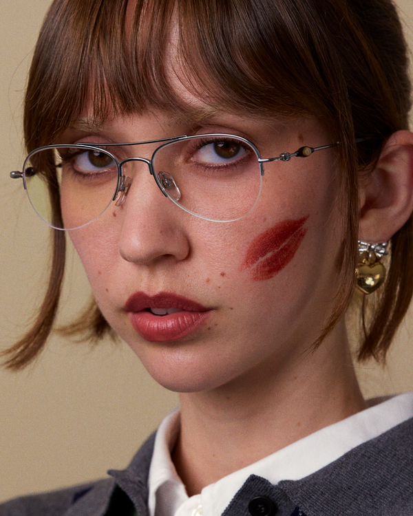 Bonnie Clyde Autobio aviator opticals in silver titanium with  blue light filtering lenses and exploding heart acetate bead detailing on the arms, on a model's face.