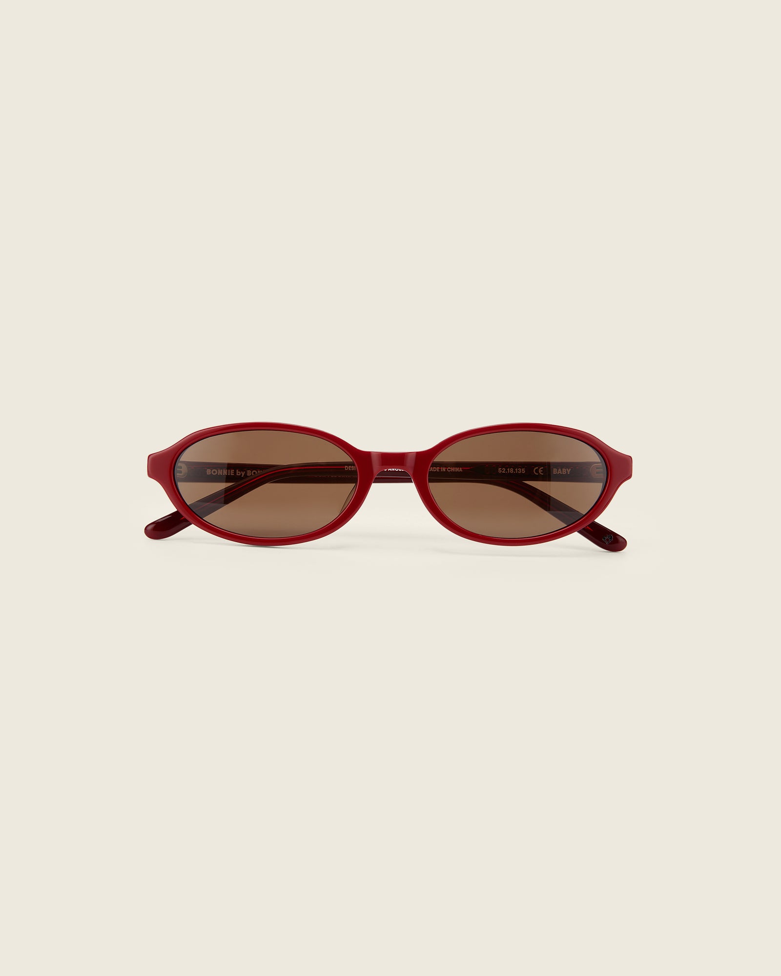 Bonnie Clyde red oval-shaped acetate sunglasses with brown lenses and double heart detailing on the arms, front view