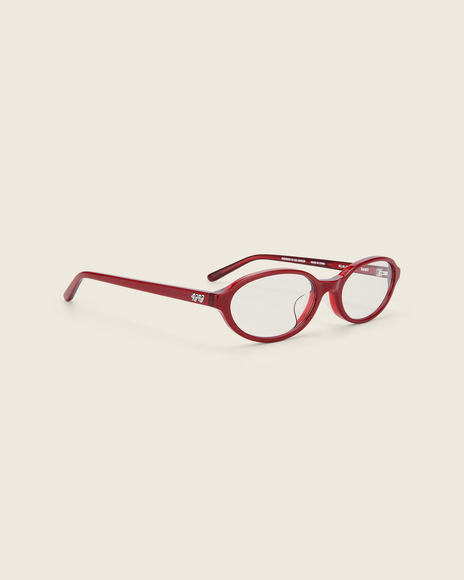 Bonnie Clyde red oval-shaped acetate glasses with clear lenses, featuring double heart detailing on the temples, three-quarter view