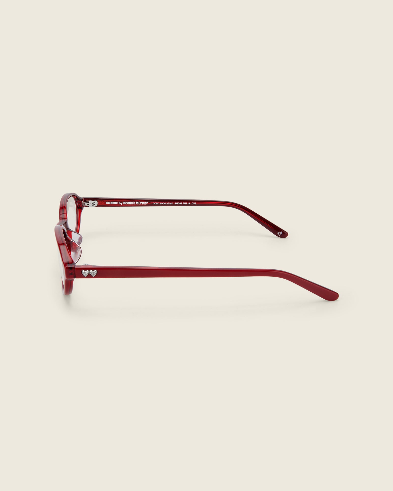 Bonnie Clyde red oval-shaped acetate glasses with clear lenses, featuring double heart detailing on the temples, side view