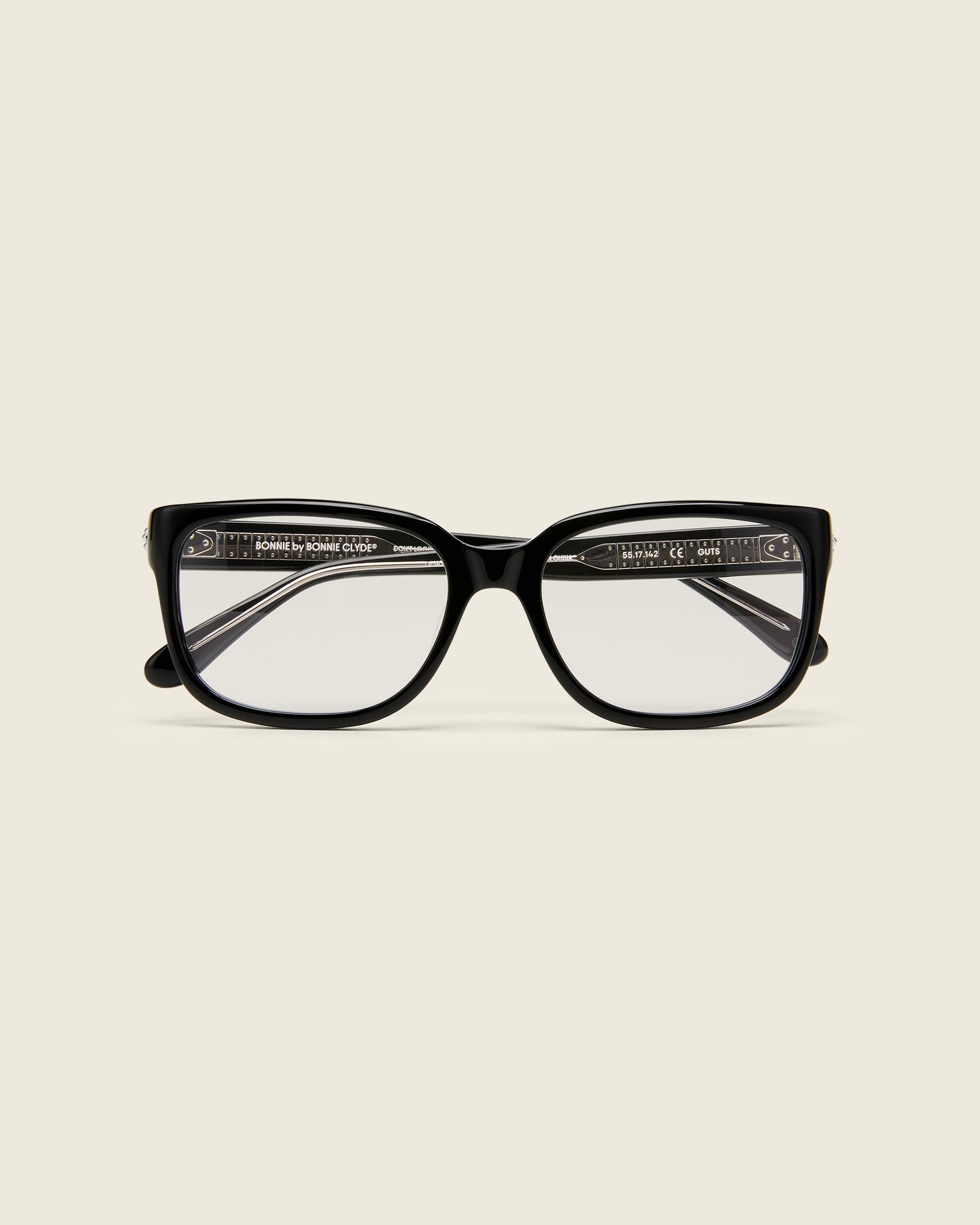 Bold, square-shaped black acetate frames on a beige background. Face view.