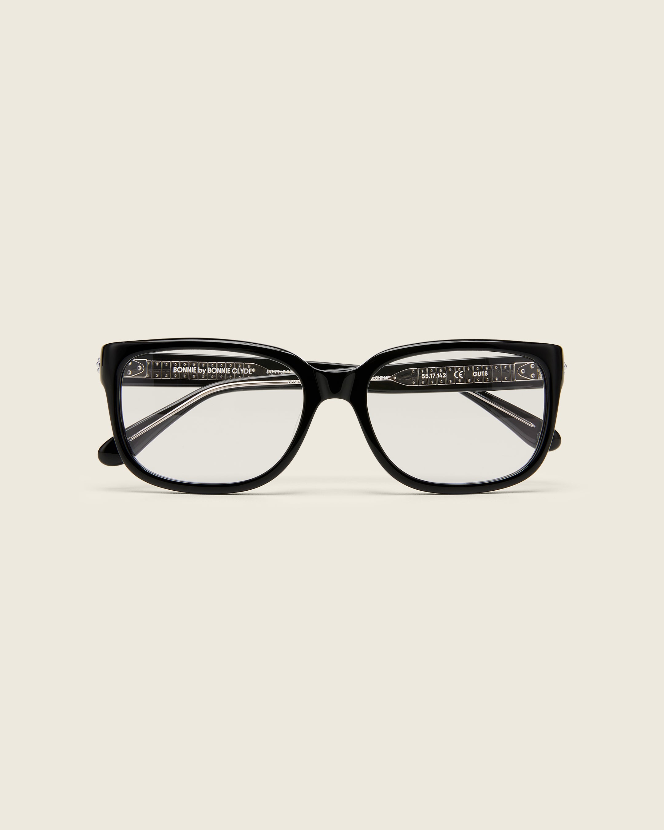 Bold, square-shaped black acetate frames on a beige background. Face view.