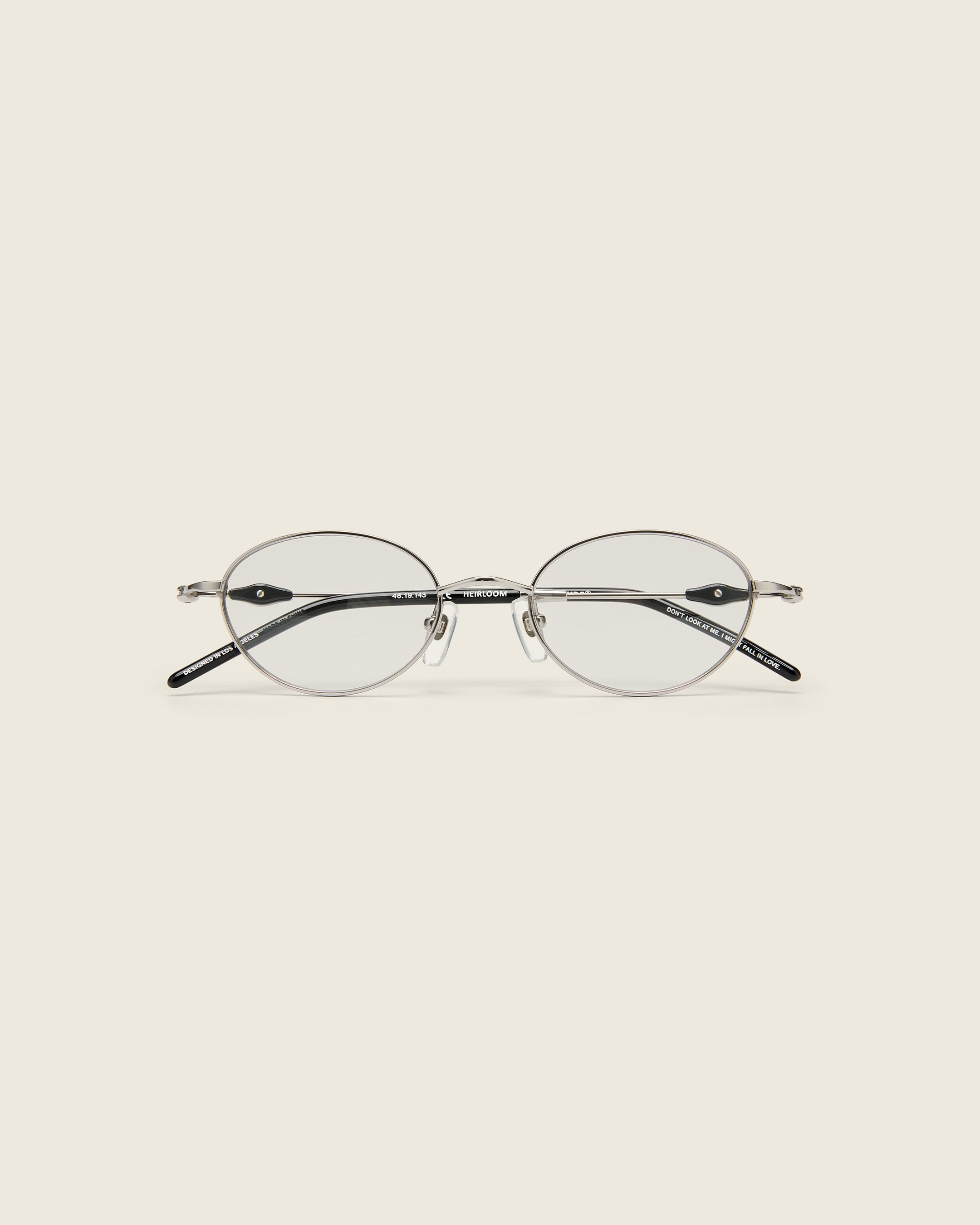 Slim, oval silver titanium frames with adjustable nose pads and lightweight acetate arm temple. Face view.