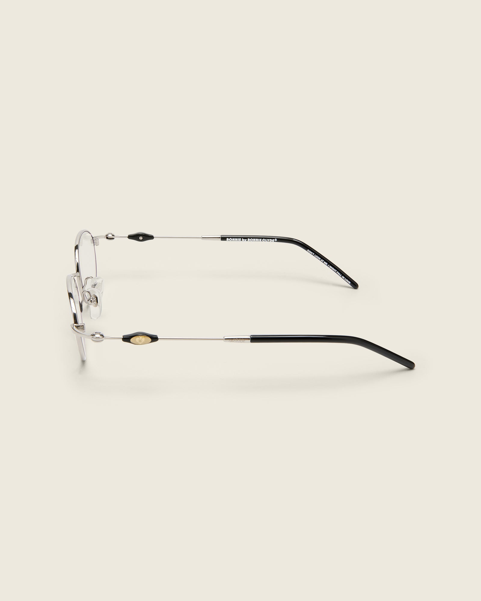 Slim, oval silver titanium frames with adjustable nose pads and acetate arm temple. Side view.