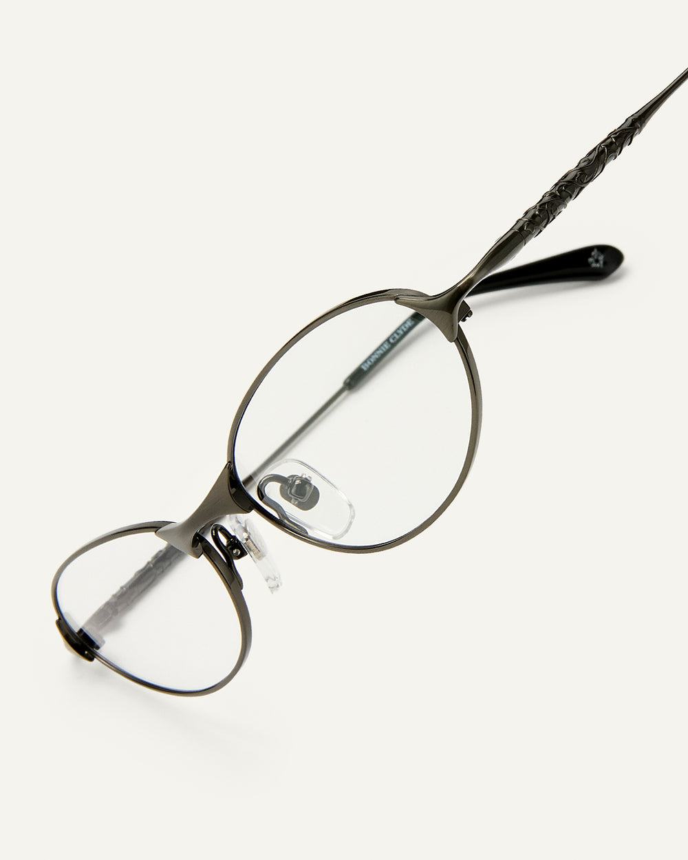 Side shot of Bonnie Clyde Intro eyeglasses in gunmetal titanium frames with black acetate details and clear lenses.