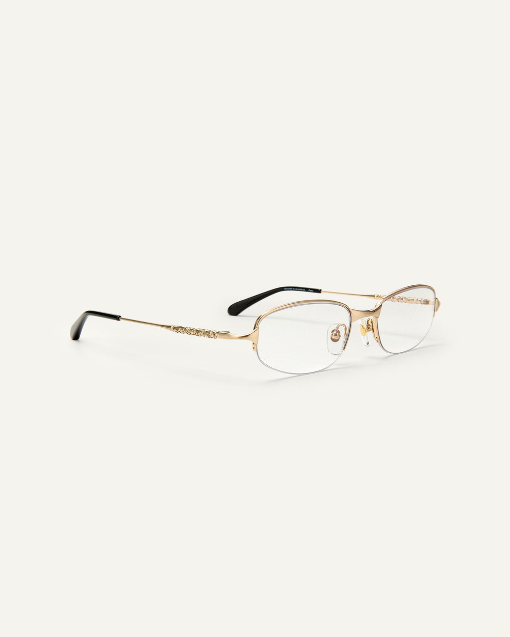 Quarter shot of Bonnie Clyde Outro eyeglasses in gold titanium frames with black acetate details and clear lenses.