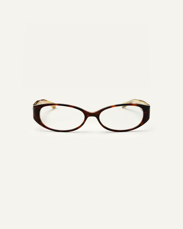 Face shot of Bonnie Clyde Precious eyeglass in layered tortoise frames with clear lenses.