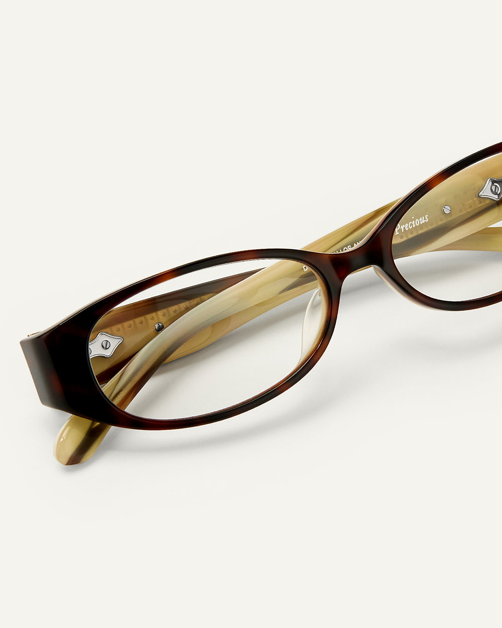 Close up shot of Bonnie Clyde Precious eyeglass in layered tortoise frames with clear lenses.