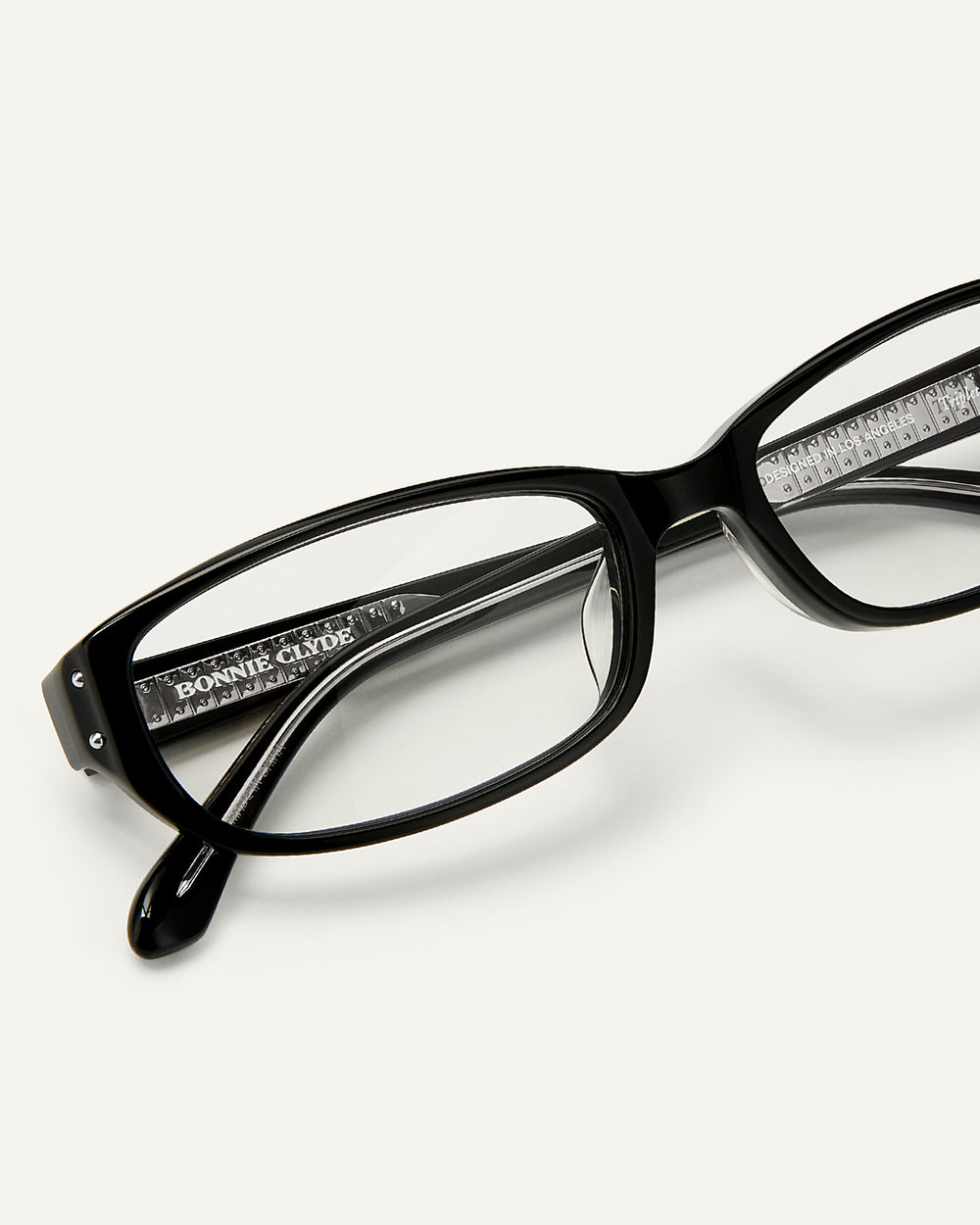 Close up shot of Bonnie Clyde Triplet eyeglasses in black frames with clear lenses.