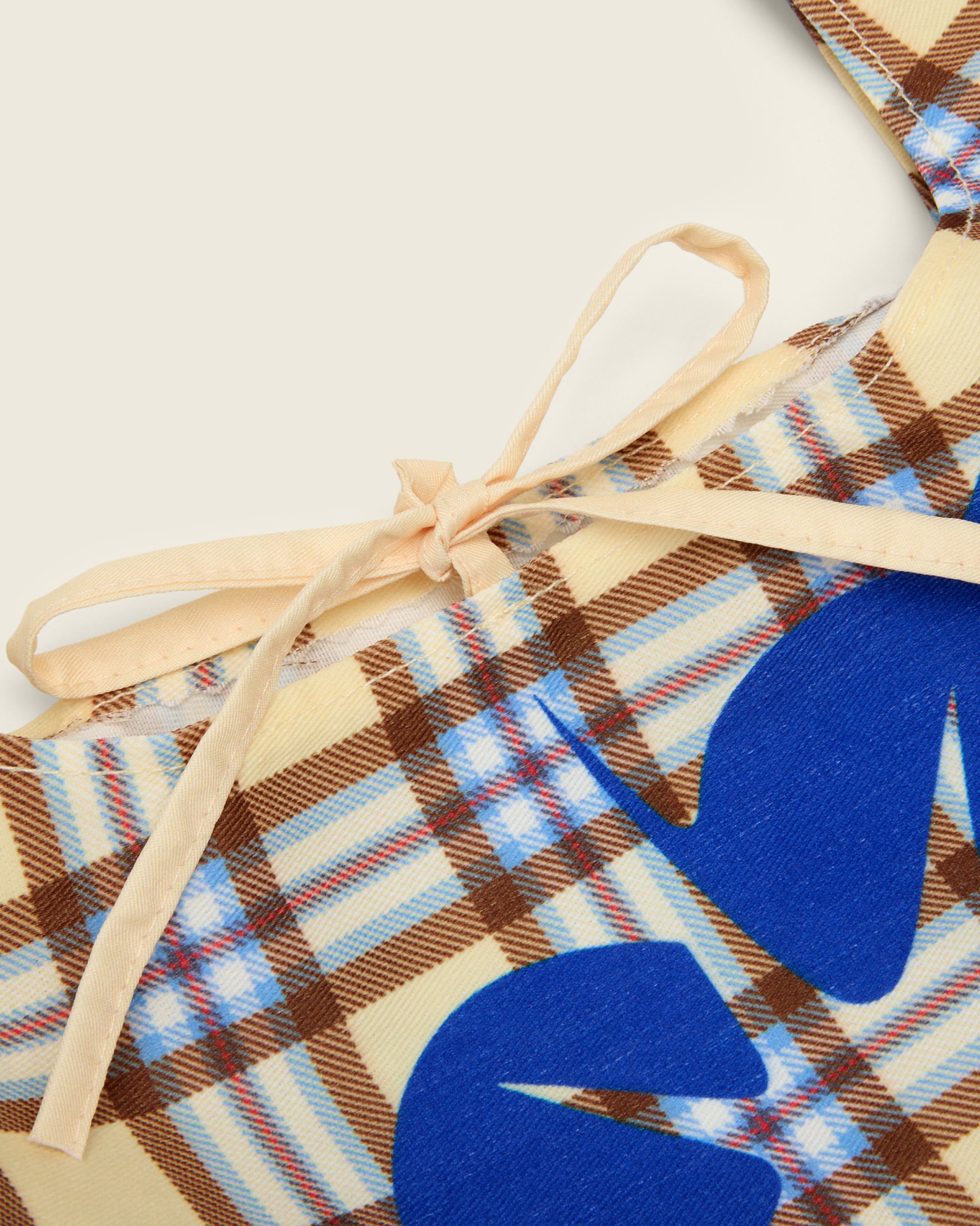 Bonnie Clyde® plaid tote bag with blue heart design on a beige background, detail shot